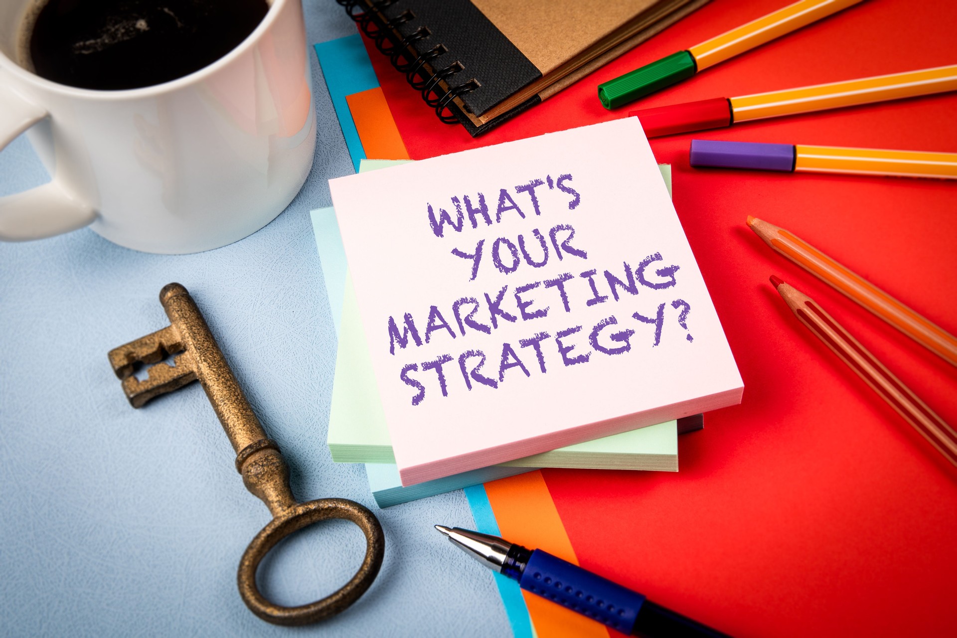 Marketing Strategy Planning with Stationery, Coffee, and Key on Colorful Office Desk